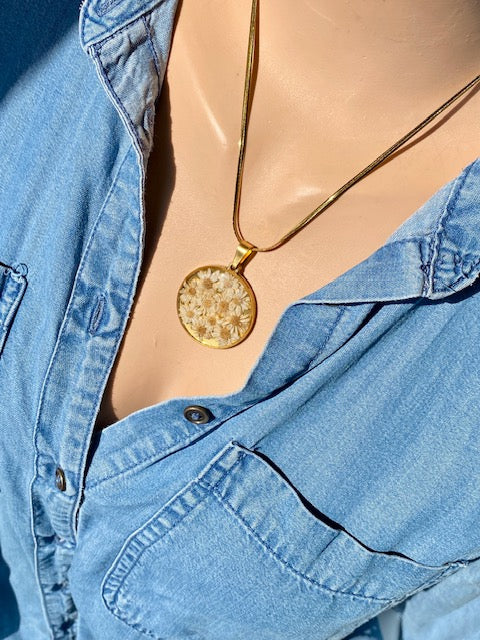 Madeliefjes in een grote ronde hanger, goldplated.