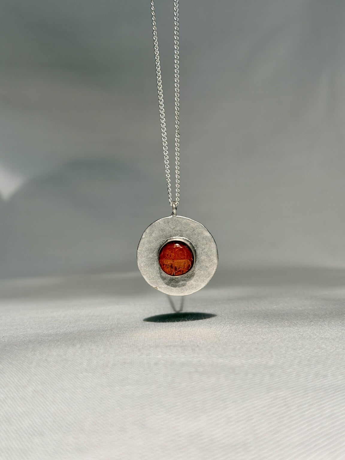 Verzilverde ronde hanger met oranje bloemblad - 25 mm