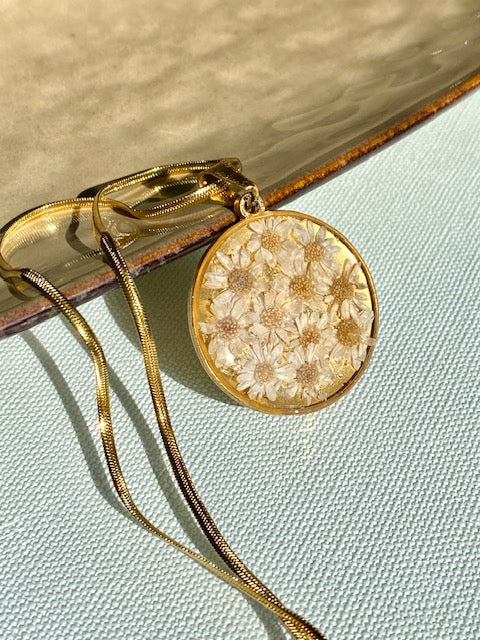 Madeliefjes in een grote ronde hanger, goldplated.