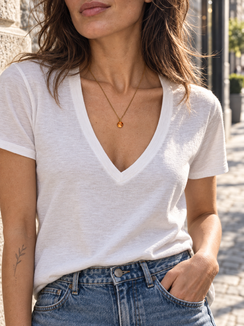 Kleine tijgerleliehanger gedragen aan een fijne vergulde ketting op model met wit tshirt
