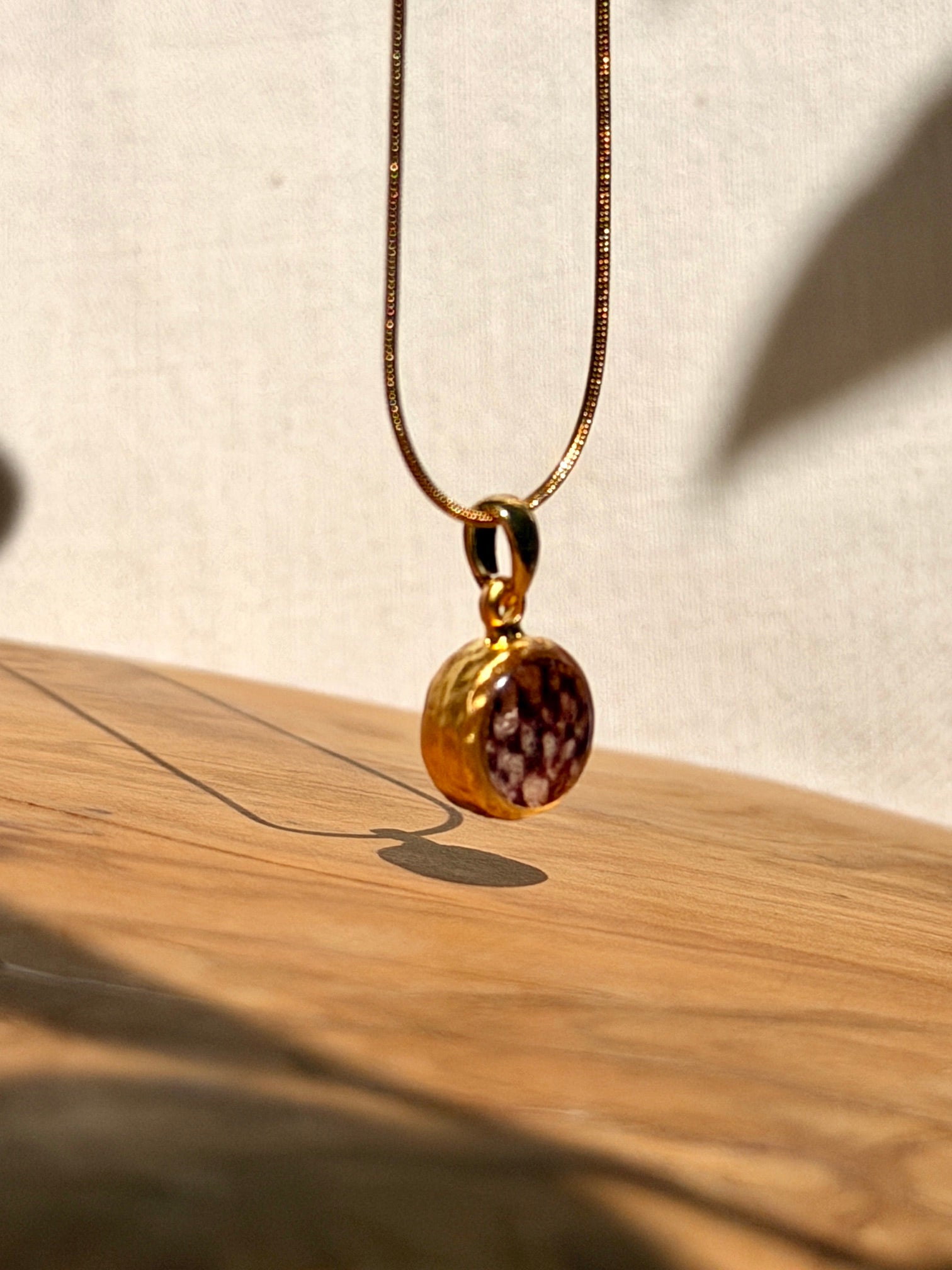 Gouden hanger met het karakteristieke patroon van een echte kievitsbloem