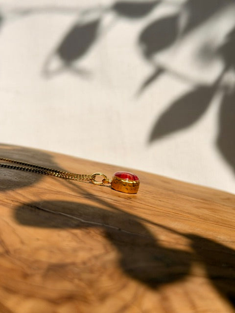 Gouden hanger met natuurlijke bladstructuur van een roze dahlia