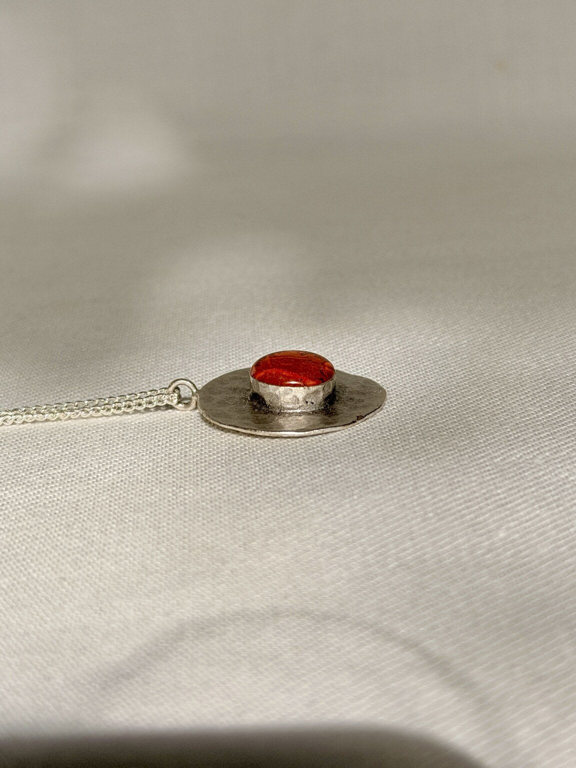 Verzilverde ronde hanger met oranje bloemblad - 25 mm