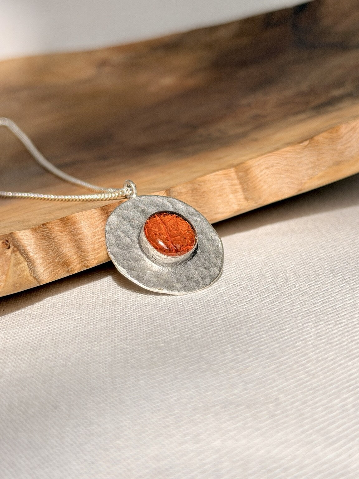 Verzilverde ronde hanger met oranje bloemblad - 25 mm